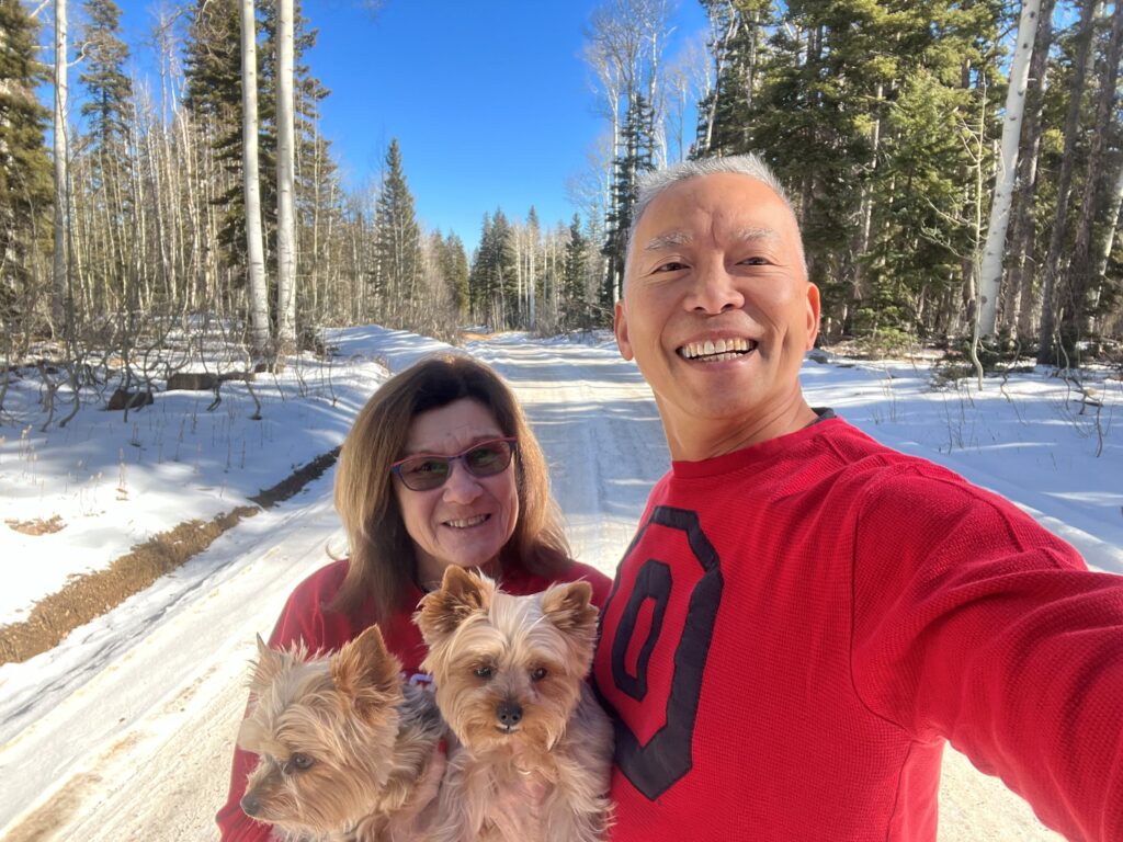 Photo of family standing in the middle of the Rimrocker Trail with snow in the background.